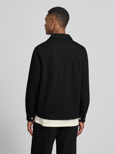 Männermodel trägt Regular Fit Overshirt mit Brusttasche Modell 'Layton' von Les Deux, Reine Baumwolle, schwarze Farbe, Ganzkörperansicht Rückansicht.