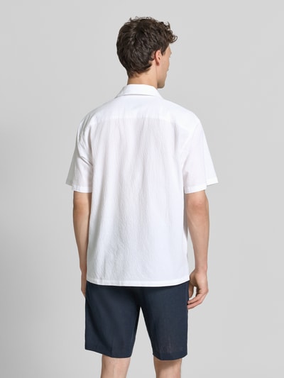 Männermodel trägt Modern Fit Freizeithemd mit Brusttasche Modell 'BLASHAWN' von Jack & Jones Premium, weiß, Strukturmuster, Ganzkörperansicht Rückansicht. Baumwoll-Mix mit Stretch-Anteil, Reverskragen, Knopfleiste, kurze Ärmel.