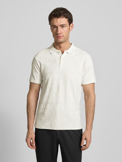 Männermodel trägt Slim Fit Poloshirt in tonalem Allover-Look von Guess, Material-Mix mit Stretch-Anteil, Polokragen, Knopfleiste, Rückenlänge bei Größe M 68 cm, helle Farbe, dezentes Muster, glatte Textur, Ganzkörperansicht von vorne.