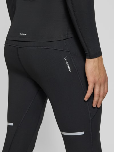 Männermodel trägt Slim Fit Trainingshose mit reflektierenden Details Modell 'adi' von adidas, schwarze Farbe, Nahaufnahme Oberschenkel, Herren Trainingshose von adidas Training