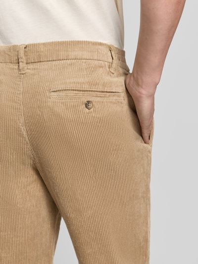 Männermodel trägt beige Tapered Fit Cordhose aus reiner Baumwolle Modell 'LEROY' von Selected, feine Rippenstruktur, Nahaufnahme Rückansicht.