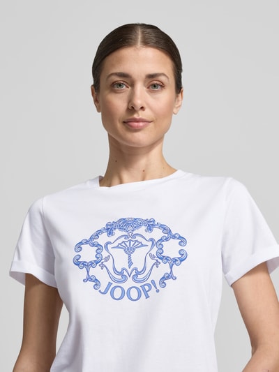 Vrouwenmodel draagt Regular Fit T-shirt met strass-steentjes model 'Tulya' van JOOP!, puur katoen, logoprint, ronde hals, nahaufnahme bovenlichaam.