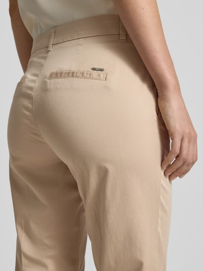 Frauenmodel trägt Hose in verkürzter Passform Modell 'MARON' von Brax in Beige, Baumwoll-Mix mit Lyocell, Detailaufnahme Rückansicht.