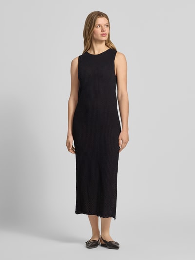 Frauenmodel trägt Maxikleid mit Rundhalsausschnitt Modell 'ZURI' von JJXX aus reine Baumwolle, körpernaher-Schnitt, schwarze Farbe, Ganzkörperansicht von vorne. Rückenlänge bei Größe S: 131 cm, Brustweite bei Größe S: 45 cm.
