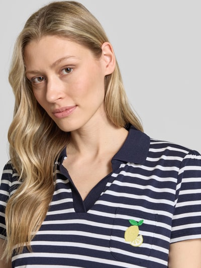 Frauenmodel trägt Regular Fit Poloshirt mit Brusttasche und Motiv-Stitching von More & More, Baumwoll-Modal-Mix mit Stretch-Anteil, Nahaufnahme Oberkörper.
