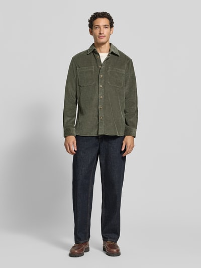 Männermodel trägt Regular Fit Hemdjacke aus Cord mit Kentkragen von Christian Berg Men, in Olivgrün, Brusttaschen, Ganzkörperansicht von vorne.