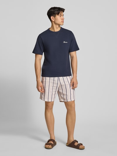 Männermodel trägt Shorts mit elastischem Bund und Logo-Detail von REVIEW aus Baumwoll-Mix, gestreift, Regular Fit, Ganzkörperansicht von vorne.
