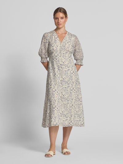 Frauenmodel trägt Midikleid mit floralem Allover-Print Modell 'Valley' von Neo Noir in Creme und Blau, taillierte Passform, Ganzkörperansicht von vorne. Rückenlänge 121 cm, Brustweite 38 cm, Ärmellänge 42 cm, V-Ausschnitt, Halbarm.