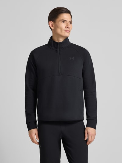 Männermodel trägt Sweatshirt mit Stehkragen von Under Armour in Schwarz, Regular Fit, Eingrifftaschen, Label-Print, Ganzkörperansicht von vorne.