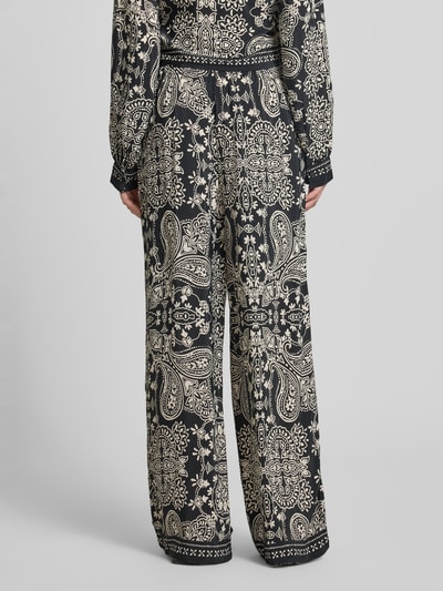 Frauenmodel trägt Loose Fit Weite Hose aus reiner Viskose Modell 'EMZA AJA' von Only, Optik: Allover-Muster, floral, Popeline, Ganzkörperansicht Rückansicht.