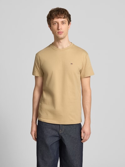 Männermodel trägt Regular Fit T-Shirt aus reiner Baumwolle von Tommy Jeans, Optik: Unifarben, Logo-Stitching, Rundhals, Kurzarm, Jersey, Ganzkörperansicht von vorne.