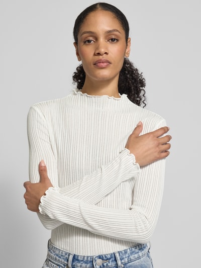 Modelka nosi Longsleeve mit Stehkragen Modell 'Sivi' od OPUS, biały, prążkowana tekstura, krój slim fit, muszelkowe wykończenie, długość tyłu 60 cm w rozmiarze 36, widok na górną część ciała z przodu.
