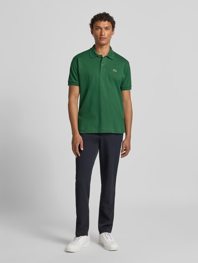 Männermodel trägt Poloshirt mit Label-Stitching Modell 'L.12.12 CORE' von LACOSTE, reine Baumwolle, Regular-Fit, Unifarbenes-Design. Ganzkörperansicht von vorne.