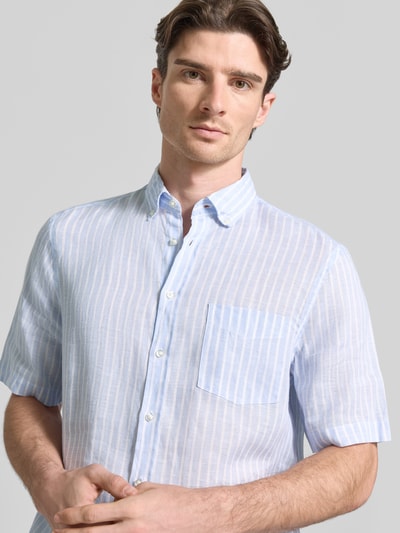 Męski model nosi Regular Fit Freizeithemd aus Leinen od Christian Berg Men, kołnierzyk typu button down, listwa guzikowa, brustasza, len, krój regular fit, krótki rękaw, szerokość w rozmiarze M: 52 cm, długość tyłu: 82 cm, długość rękawów: 28 cm, jasnoniebieskie paski, lekka struktura, widok na górną część tułowia z przodu