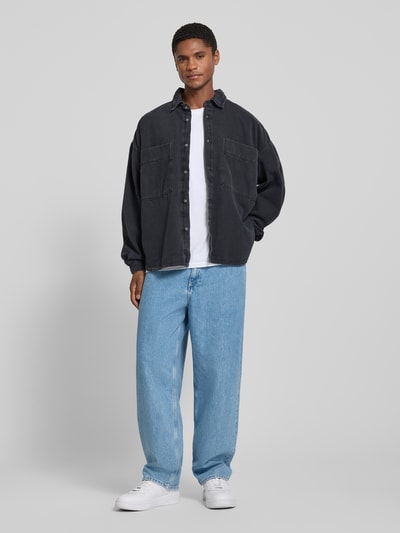 Männermodel trägt Relaxed Fit Jeanshemd mit Kentkragen Modell 'JAZY' von American Vintage, Reine Baumwolle, Ganzkörperansicht von vorne.