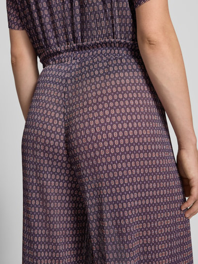 Vrouwenmodel draagt Wide Fit broek met elastische band van Rich & Royal, plooien-look, all-over bloemenprint, detailopname achterzijde.