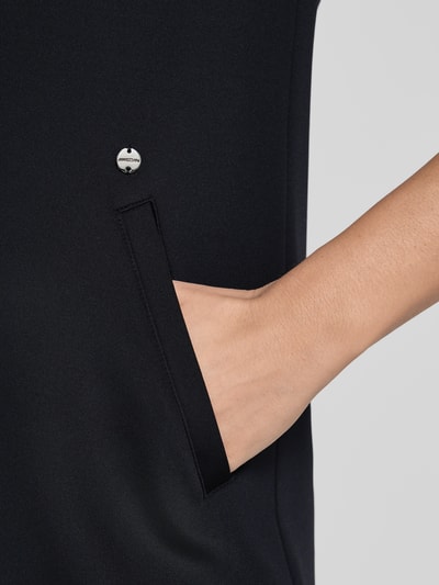 Frauenmodel trägt Knielanges Kleid mit seitlichen Eingrifftaschen von Marc Cain aus Material-Mix mit Stretch-Anteil, Detailaufnahme.