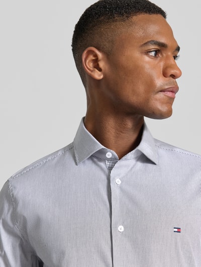 Männermodel trägt Slim Fit Businesshemd aus Baumwoll-Mix von Tommy Hilfiger Tailored, wzór w paski, wyhaftowane logo, mieszanka bawełny, Nahaufnahme Oberkörper