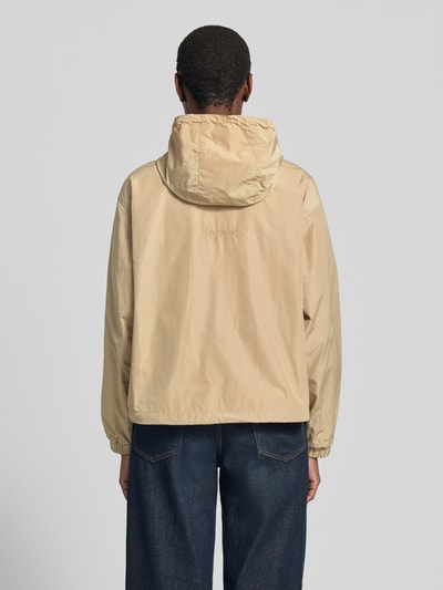 Frauenmodel trägt Jacke mit Kapuze und Zweiwege-Reißverschluss von Smith and Soul in Beige, Relaxed-Fit, Rückenlänge 58 cm, Schulterbreite 52 cm, Brustweite 60 cm, Ärmellänge 57 cm, Eingrifftaschen, Ganzkörperansicht Rückansicht.