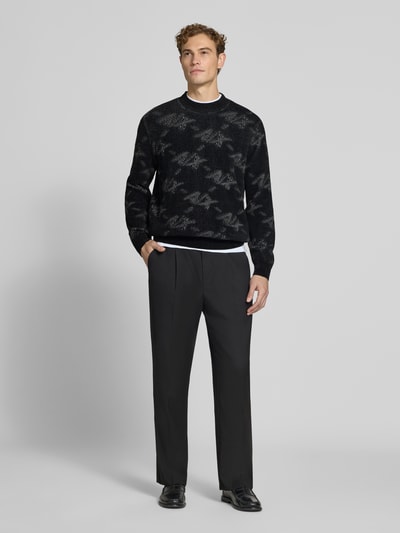 Männermodel trägt Regular Fit Pullover mit Viskose-Anteil von Armani Exchange, schwarz-grau gemustert, Material-Mix, Ganzkörperansicht von vorne.