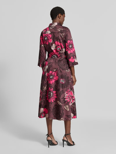 Frauenmodel trägt Midikleid aus reiner Baumwolle von Christian Berg Woman mit floralem Print in Lila und Pink, Ganzkörperansicht Rückansicht. Taillierte Passform, Umlegekragen, integriertes Taillenband, 1/2-Arm, Rückenlänge 123 cm, Brustweite 50 cm, Ärmellänge 47 cm.