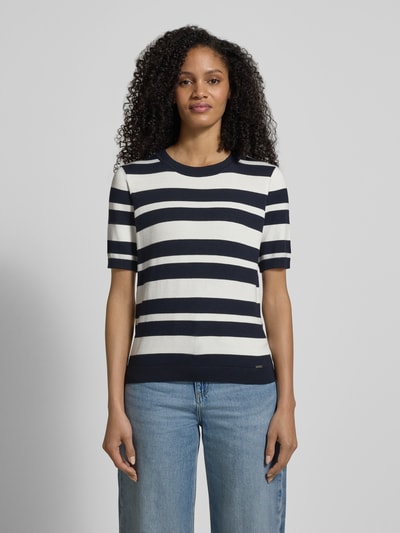 Frauenmodel trägt Strickshirt mit Rundhalsausschnitt und Label-Detail von More & More, gestreift in Blau und Weiß, Regular Fit, Viskose-Elasthan-Mix, Ganzkörperansicht von vorne.