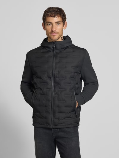 Männermodel trägt schwarze Regular Fit Steppjacke mit winddichter Funktion von Strellson, glatte Textur, Ganzkörperansicht von vorne, Herren Steppjacke von Strellson.