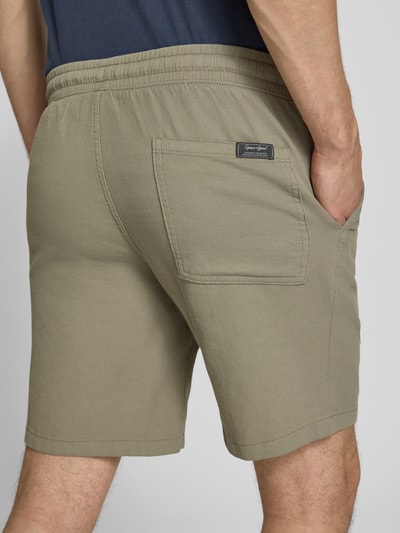 Männermodel trägt Shorts mit Strukturmuster Modell 'JAIDEN' von Jack & Jones aus reiner Baumwolle, Regular-Fit, elastischer Bund mit Tunnelzug, Beige, Textur matt, Ganzkörperansicht Rückansicht.