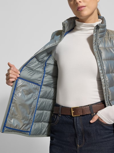 Vrouwenmodel draagt Steppweste mit Stehkragen van NAUTGÅRD in regular fit met ritssluiting en ritszakken, detailopname bovenlichaam. Ruglengte maat S: 64 cm, schouderbreedte: 35 cm, borstwijdte: 46 cm.