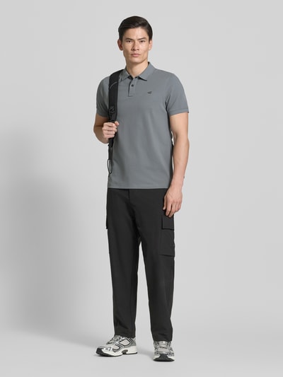 Mannenmodel draagt Regular Fit Poloshirt in unifarbenem Design van camel active, katoen-elastaan mix, met knoopsluiting en logo, grijs, rechte broek, vooraanzicht volledig lichaam.