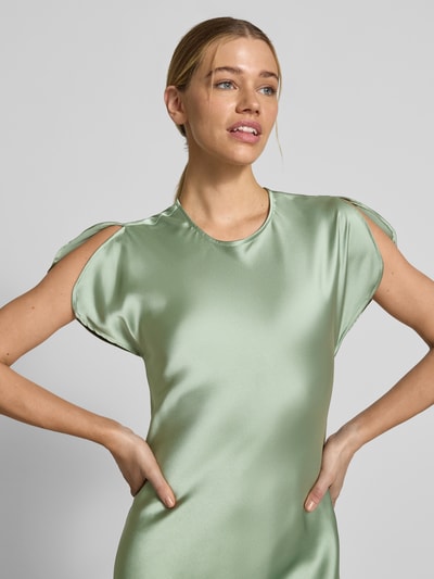 Frauenmodel trägt Cocktailkleid mit Rundhalsausschnitt Modell 'Miley' von GUIDO MARIA KRETSCHMER WOMAN in mintgrünem Satin, körpernaher Schnitt, Ärmel mit Schlitz, Nahaufnahme Oberkörper.