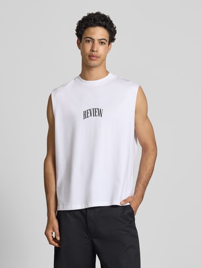 Männermodel trägt Muskelshirt mit Logo und Rundhalsausschnitt von REVIEW in Weiß, Reine Baumwolle, Regular-Fit, Logo, Rückenlänge 68 cm, Nahaufnahme Oberkörper.