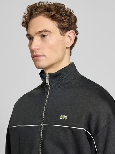 Männermodel trägt Regular Fit Sweatjacke mit Baumwoll-Anteil von Lacoste, Optik: Unifarben, Logo-Detail, Kontraststreifen, Nahaufnahme Oberkörper.