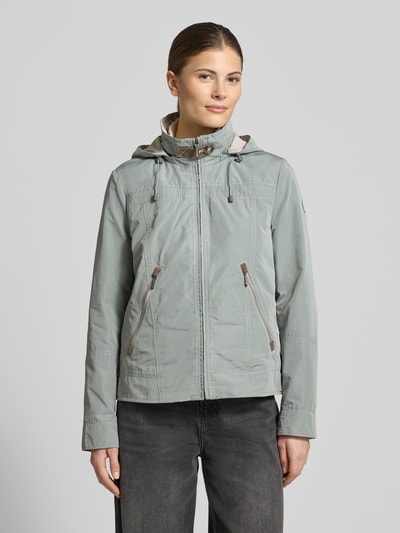 Vrouwenmodel draagt Jacke mit Kapuze und Reißverschlusstaschen van Gil Bret in lichtgrijs, regular fit, lichte glans, opstaande kraag, vooraanzicht borst close-up