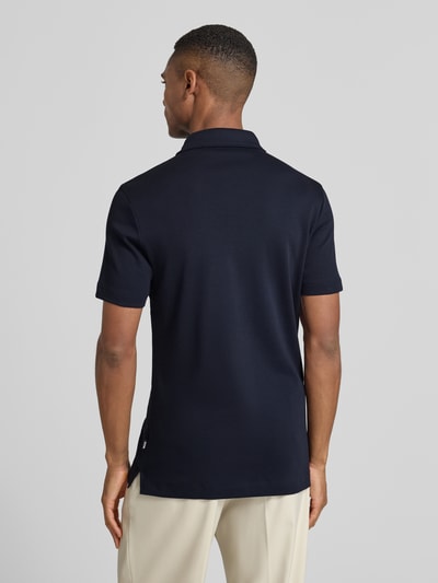 Männermodel trägt Poloshirt mit Brand-Schriftzug von BOSS aus reiner Baumwolle in Navy, Regular Fit, Ganzkörperansicht Rückansicht.