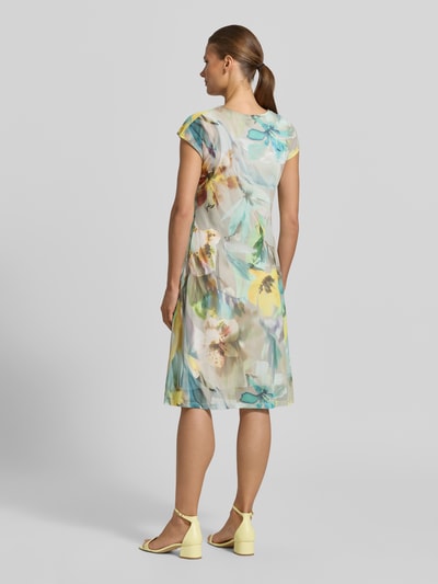 Frauenmodel trägt Minikleid mit V-Ausschnitt und Knotendetail von Betty Barclay, Material-Mix mit Stretch-Anteil, Allover-Look, taillierter Schnitt, Rückansicht Ganzkörperansicht.