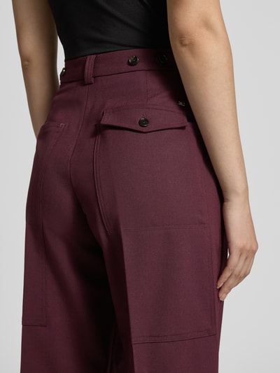Vrouwenmodel draagt Loose Fit wijdte broek uit wolmix van Tommy Hilfiger, look: effen kleuren, materiaalverwerking: twill, klepzakken, logo-applicatie, persplooien, riemlussen, knoopsluiting en ritssluiting, detailopname rechter achterzijde.