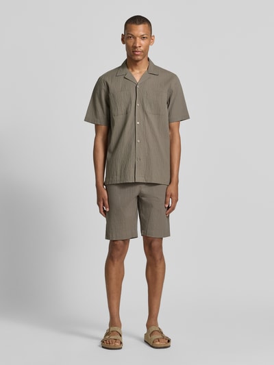 Männermodel trägt Shorts mit elastischem Bund und Strukturmuster von Lindbergh, Baumwoll-Mix mit Stretch-Anteil, Loose-Fit, Ganzkörperansicht von vorne.