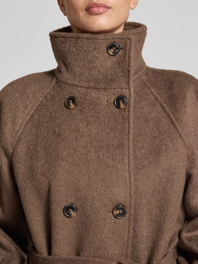 Modelka kobieca nosi Wollmantel mit doppelreihiger Knopfleiste von JAKE*S WOMAN CASUAL, brązowy kolor jednolity, stehnij kołnierz, raglanowe rękawy z mankietami, pasek w talii, wyrazista faktura materiału, zbliżenie na górną część ciała.