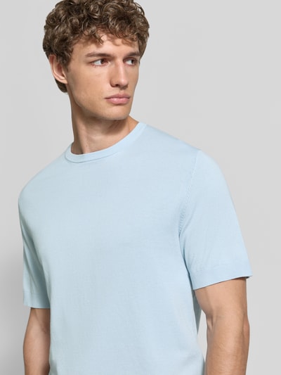 Mannenmodel draagt Regular Fit T-shirt uit puur biologisch katoen model 'TORINO' van SELECTED HOMME, look: effen, fijne textuur, ronde hals, korte mouw, geribde mouwboord, fijngebreid, materiaal: puur biologisch katoen. Nahaufnahme oberkörper.