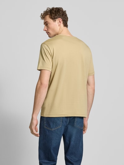 Męski model ma na sobie Regular Fit T-Shirt mit Logo-Stitching od Gant, bawełna, beżowy kolor, jeansy, widok całej sylwetki z tyłu.