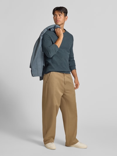 Männermodel trägt Regular Fit Pullover aus reiner Baumwolle Modell 'Hill' von JACK & JONES, Strick-Optik, Ganzkörperansicht von vorne. Damen Pullover aus dem Kontext.