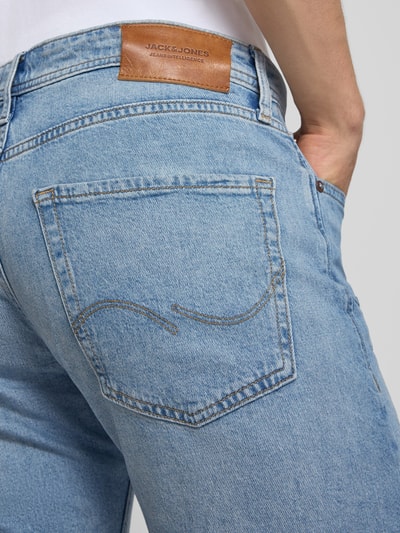 Männermodel trägt Regular Fit Jeansshorts mit Umschlag Modell 'RICK' von Jack & Jones, hellblaue Denimstruktur, Nahaufnahme Rückansicht. Baumwoll-Elasthan-Mix, Eingrifftaschen, Bundweite Größe M 42 cm, Innenbeinlänge 21 cm.