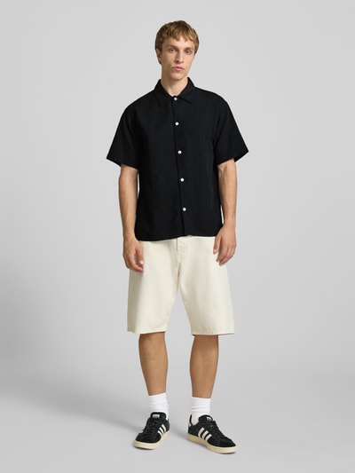 Mannenmodel draagt Regular fit vrijetijdsoverhemd met structuurpatroon model 'MONTAUK' van Jack & Jones in puur katoen, kentkraag en knoopsluiting, ruglengte 70 cm, schouderbreedte 41 cm, mouwlengte 28 cm, zwart, voorkant volledig zichtbaar, Ganzkörperansicht von vorne.