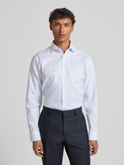 Męski model nosi Regular Fit Business Koszulę z bawełny z kołnierzykiem typu kent i listwą guzikową marki SEIDENSTICKER, biała z niebieskim wzorem, długość tyłu 81 cm, szerokość ramion 47 cm, długość rękawów 66 cm, widok całej sylwetki z przodu.