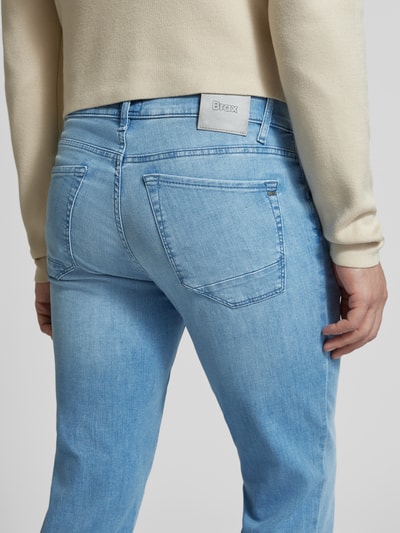 Männermodel trägt Slim Fit Jeans mit Eingrifftaschen Modell 'Chuck' von BRAX, hellblau, Baumwoll-Elasthan-Mix, Detailaufnahme Rückansicht. Bundweite bei Größe 32/32: 43 cm, Innenbeinlänge: 81 cm.