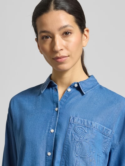 Frauenmodel trägt Boxy Fit Bluse aus Lyocell mit Label-Detail von Smith and Soul im Denim-Look, Nahaufnahme Oberkörper.