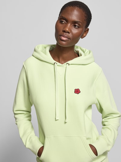 Frauenmodel trägt Hoodie aus reiner Baumwolle von Kenzo in hellem Grün mit Känguru-Tasche, Kapuze mit Tunnelzug, Regular-Fit, Nahaufnahme Oberkörper.