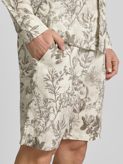 Männermodel trägt Shorts aus Leinen-Mix mit Eingrifftaschen von MCNEAL in Beige mit floralem Print, strukturierte Oberfläche, Nahaufnahme Oberschenkel, Herren Shorts Leinen-Baumwoll-Mix, gerader Schnitt, elastischer Bund mit Kordelzug, französische Eingrifftaschen, Gesäßtasche, Bundweite 43 cm, Innenbeinlänge 23 cm.