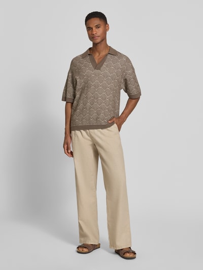 Männermodel trägt Relaxed Fit Poloshirt mit V-Ausschnitt Modell 'LAURENZZO' von Drykorn, Baumwoll-Mix, Allover-Look, Ganzkörperansicht von vorne.